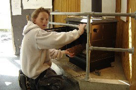 Student adding wood to fire. 