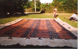 The Completed Tapa Cloth: <P>This is the completed tapa cloth which has been decorated with black dye. The standard length of a big cloth is 50 feet. The patterns may be personal favourites or traditional or family designs. The more dye which is used on the painting the higher the value of the cloth.</P>  <P>Tapa cloths such as this are usually valued at $800-$1000. A special prize tapa may fetch $1200. This particular tapa cloth made by the  Vaka family was photographed just in time as it was sold shortly afterwards for $1200.</P>